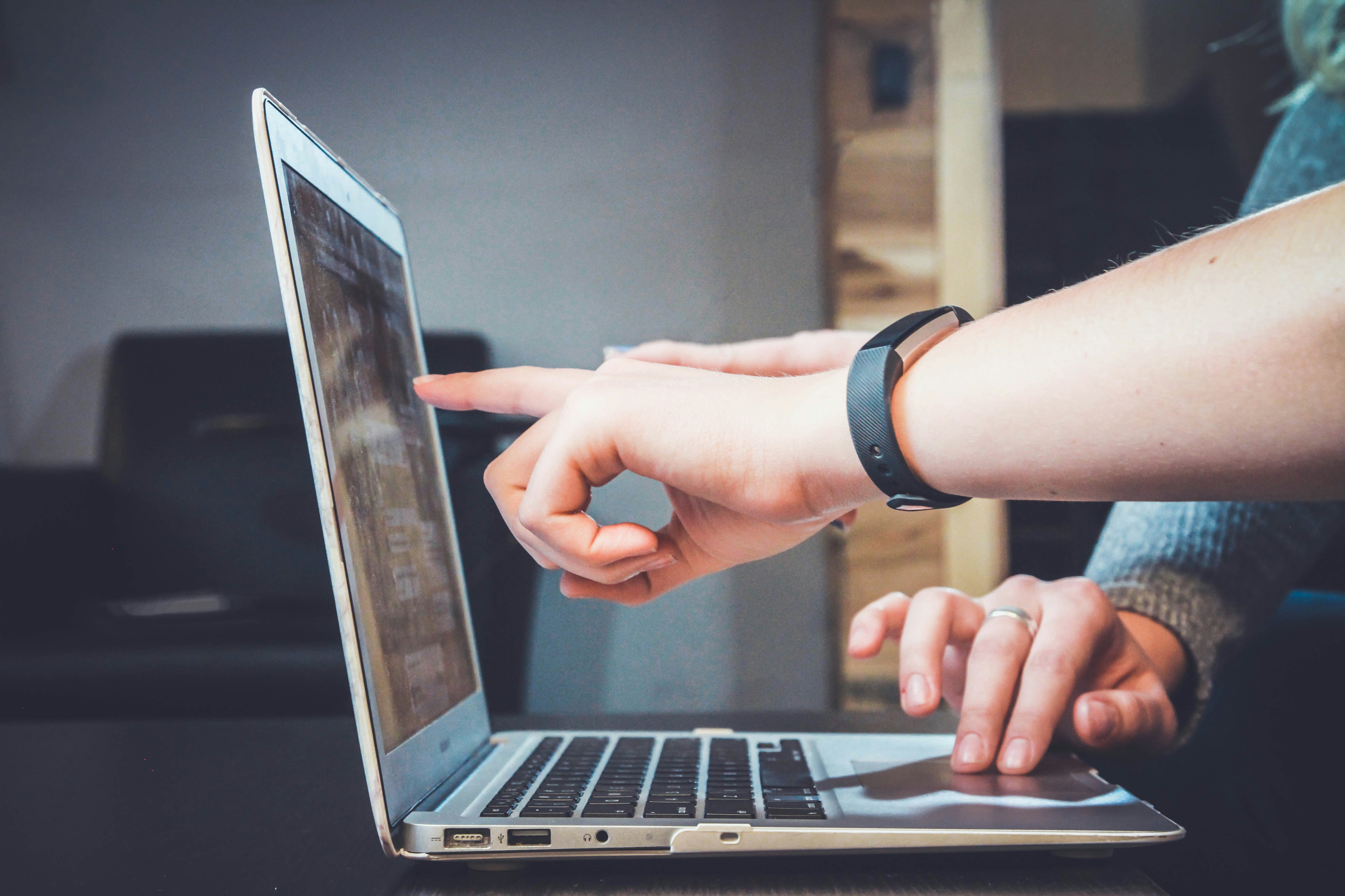 2 Employees pointing at a laptop