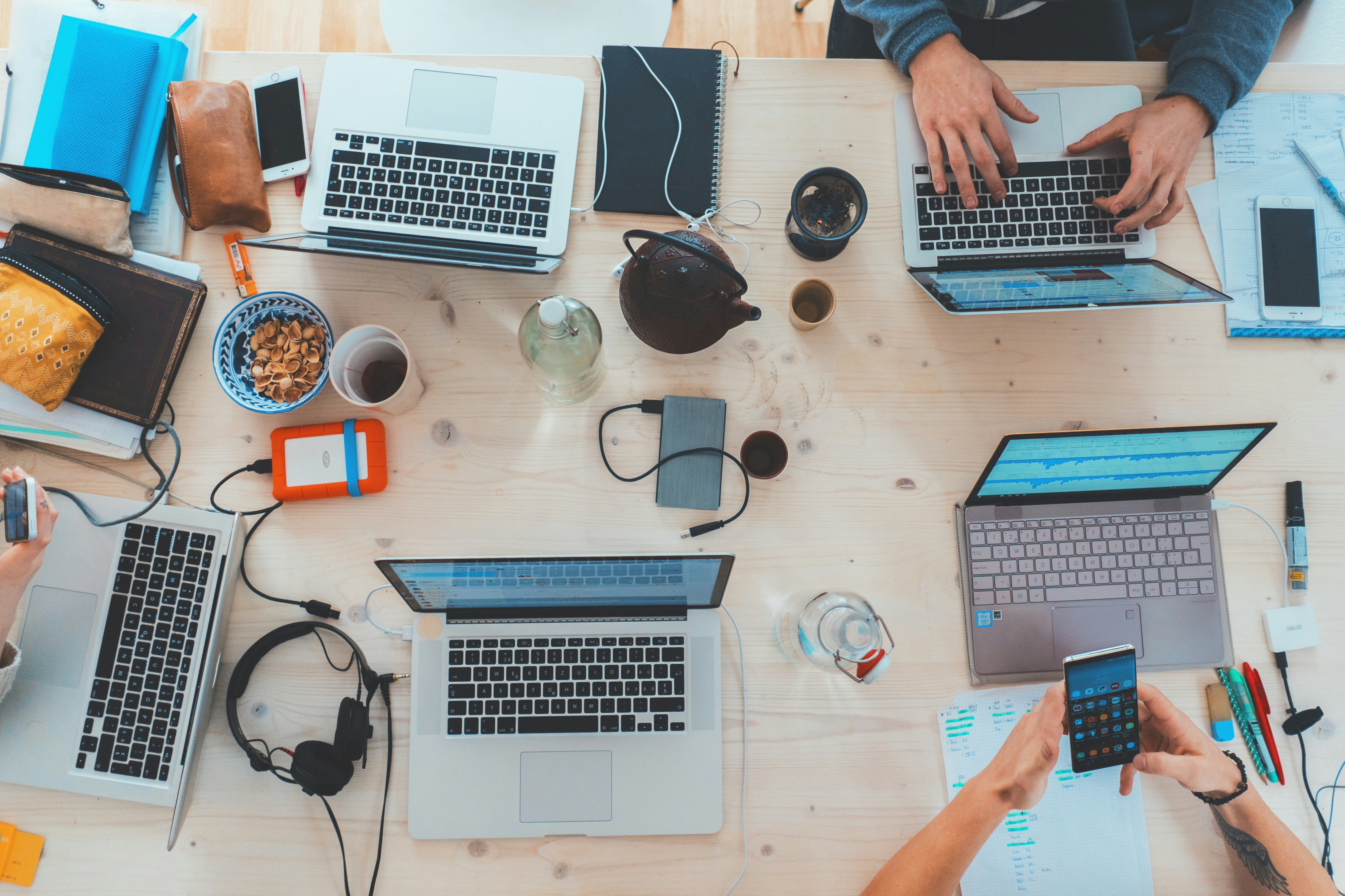 4 Laptops showing startup employees working together on a table.jpg